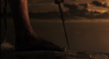 Movie still from “Cast Away” (2000), directed by Robert Zemeckis – A person standing on a rock with a stick; Extreme Close Up shot, Low angle