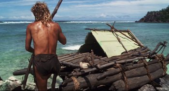 Movie still from “Cast Away” (2000), directed by Robert Zemeckis – A man standing on top of a raft in the ocean; Wide shot, High angle