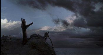 Movie still from “Cast Away” (2000), directed by Robert Zemeckis – A person standing on top of a rock near the ocean; Extreme Wide shot, Low angle