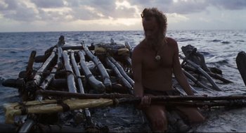 Movie still from “Cast Away” (2000), directed by Robert Zemeckis – A man sitting on a raft in the ocean; Wide shot, High angle