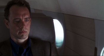 Movie still from “Cast Away” (2000), directed by Robert Zemeckis – A man sitting on a plane looking out the window; Close Up shot, Low angle