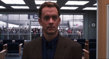 Movie still from “Cast Away” (2000), directed by Robert Zemeckis – A man in a suit and tie in front of a crowd of onlookers; Close Up shot, Over the shoulder angle