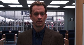 Movie still from “Cast Away” (2000), directed by Robert Zemeckis – A man in a suit and tie in front of a crowd of onlookers; Close Up shot, Low angle