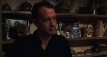 Movie still from “Cast Away” (2000), directed by Robert Zemeckis – A person sitting in a room; Close Up shot, Over the shoulder angle