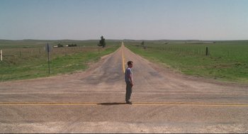 Movie still from “Cast Away” (2000), directed by Robert Zemeckis – A man standing on the side of a road in the middle of nowhere; Extreme Wide shot, High angle