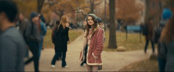 Movie still from “Cherry” (2021), directed by Joe Russo – A girl in a pink coat is standing on the sidewalk; Medium shot, Over the shoulder angle