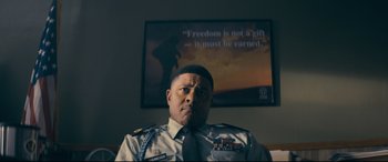Movie still from “Cherry” (2021), directed by Joe Russo – A man in uniform sitting in front of a picture; Close Up shot, Low angle