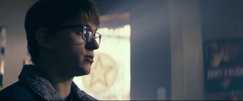 Movie still from “Cherry” (2021), directed by Joe Russo – A man with glasses is looking into the distance; Close Up shot, Low angle