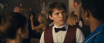 Movie still from “Cherry” (2021), directed by Joe Russo – A man in a red vest and a black bow tie; Close Up shot, Over the shoulder angle