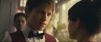 Movie still from “Cherry” (2021), directed by Joe Russo – A young man in a bow tie talking to a young woman; Close Up shot, Over the shoulder angle
