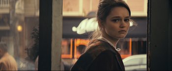 Movie still from “Cherry” (2021), directed by Joe Russo – A woman standing next to a fire place in a room; Close Up shot, Over the shoulder angle