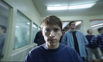 Movie still from “Cherry” (2021), directed by Joe Russo – A group of young men standing in a hallway; Close Up shot, Low angle