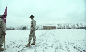 Movie still from “Cherry” (2021), directed by Joe Russo – A man standing in the middle of a snow covered field; Wide shot, Low angle