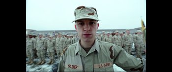 Movie still from “Cherry” (2021), directed by Joe Russo – A man in a military uniform standing in front of a group of soldiers; Close Up shot, Low angle