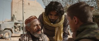 Movie still from “Cherry” (2021), directed by Joe Russo – Two men and a man with a beard talking to another man; Medium shot, Over the shoulder angle