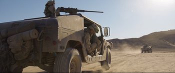 Movie still from “Cherry” (2021), directed by Joe Russo – A military vehicle driving down a dirt road; Wide shot, Low angle