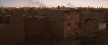 Movie still from “Cherry” (2021), directed by Joe Russo – A man standing on top of a building on top of a building; Extreme Wide shot, Low angle