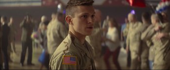 Movie still from “Cherry” (2021), directed by Joe Russo – A man in a military uniform with an american flag patch on his chest; Close Up shot, Over the shoulder angle