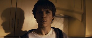 Movie still from “Cherry” (2021), directed by Joe Russo – A young man is looking into the camera; Close Up shot, Low angle