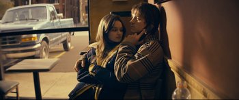 Movie still from “Cherry” (2021), directed by Joe Russo – A man and a woman sitting next to each other on a bench; Medium shot, Low angle