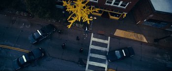Movie still from “Cherry” (2021), directed by Joe Russo – An aerial view of a person crossing a street; Extreme Wide shot, Overhead angle