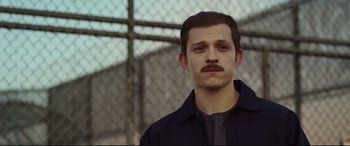 Movie still from “Cherry” (2021), directed by Joe Russo – A man with a beard and mustache wearing a black jacket; Close Up shot, Over the shoulder angle