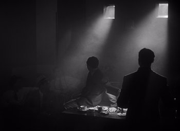 Movie still from “Citizen Kane” (1941), directed by Orson Welles – A group of people sitting around a table in a room; Wide shot, Low angle