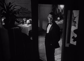 Movie still from “Citizen Kane” (1941), directed by Orson Welles – A black and white photo of a man in a tuxedo; Medium shot, Over the shoulder angle