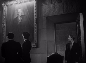 Movie still from “Citizen Kane” (1941), directed by Orson Welles – Three men standing in front of a large portrait of a man; Medium shot, Low angle