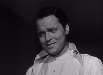 Movie still from “Citizen Kane” (1941), directed by Orson Welles – Black and white photograph of a man in a white shirt; Close Up shot, Low angle