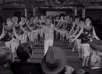 Movie still from “Citizen Kane” (1941), directed by Orson Welles – An old photo of a group of people dancing; Wide shot, Low angle