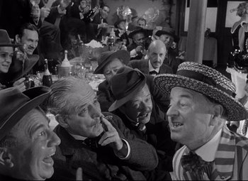 Movie still from “Citizen Kane” (1941), directed by Orson Welles – A group of men sitting at a table with hats on; Medium shot, Over the shoulder angle