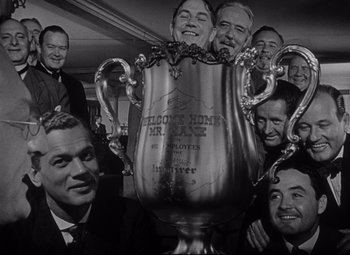Movie still from “Citizen Kane” (1941), directed by Orson Welles – A black and white photo of a group of men holding a trophy; Medium shot, Low angle