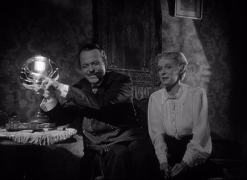 Movie still from “Citizen Kane” (1941), directed by Orson Welles – A man and a woman sitting at a table; Medium shot, Low angle