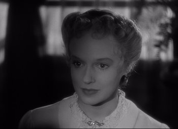 Movie still from “Citizen Kane” (1941), directed by Orson Welles – A black - and - white photo of a woman in a white dress; Close Up shot, Over the shoulder angle