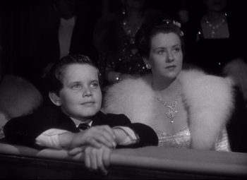 Movie still from “Citizen Kane” (1941), directed by Orson Welles – A man and a woman sitting next to each other; Medium shot, High angle