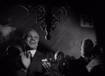 Movie still from “Citizen Kane” (1941), directed by Orson Welles – Black and white photograph of a man in a suit and tie; Medium shot, Low angle