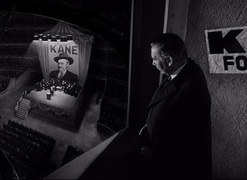 Movie still from “Citizen Kane” (1941), directed by Orson Welles – A black and white photo of a man in a suit and tie; Wide shot, High angle