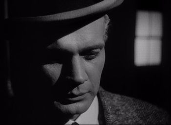 Movie still from “Citizen Kane” (1941), directed by Orson Welles – A black and white photo of a man wearing a hat; Close Up shot, Low angle