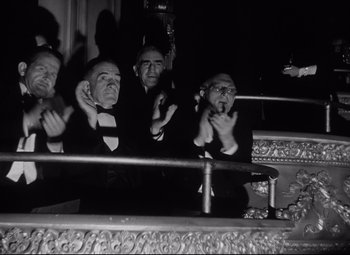 A group of men sitting next to each other on a stage