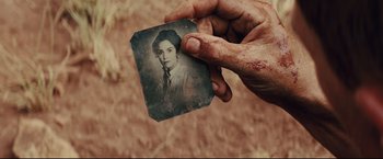 Movie still from “Cowboys & Aliens” (2011), directed by Jon Favreau – An old photo of a woman with blood all over her face; Extreme Close Up shot, High angle