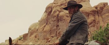 Movie still from “Cowboys & Aliens” (2011), directed by Jon Favreau – A man with a long beard wearing a cowboy hat; Medium shot, Low angle