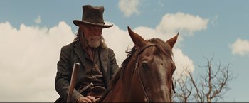 Movie still from “Cowboys & Aliens” (2011), directed by Jon Favreau – An old man sitting on the back of a brown horse; Medium shot, Low angle