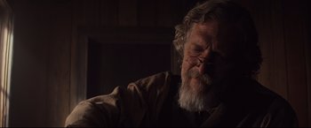 Movie still from “Cowboys & Aliens” (2011), directed by Jon Favreau – An older man with a beard and glasses; Close Up shot, Over the shoulder angle