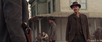Movie still from “Cowboys & Aliens” (2011), directed by Jon Favreau – A group of men standing in front of a house; Medium shot, Low angle