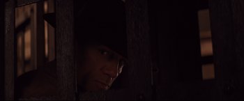 Movie still from “Cowboys & Aliens” (2011), directed by Jon Favreau – A man with a hat looking out of a window; Close Up shot, Over the shoulder angle