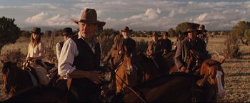 Movie still from “Cowboys & Aliens” (2011), directed by Jon Favreau – A group of men riding horses on a dirt road; Medium shot, Low angle