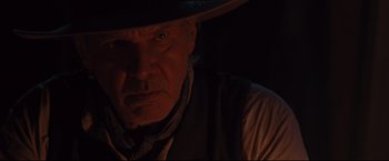 Movie still from “Cowboys & Aliens” (2011), directed by Jon Favreau – An older man wearing a cowboy hat in the dark; Close Up shot, Over the shoulder angle