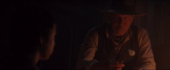 Movie still from “Cowboys & Aliens” (2011), directed by Jon Favreau – An older man in a cowboy hat is looking at a cell phone; Close Up shot, Over the shoulder angle