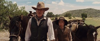 Movie still from “Cowboys & Aliens” (2011), directed by Jon Favreau – A man and a boy are standing in a field; Medium shot, Low angle